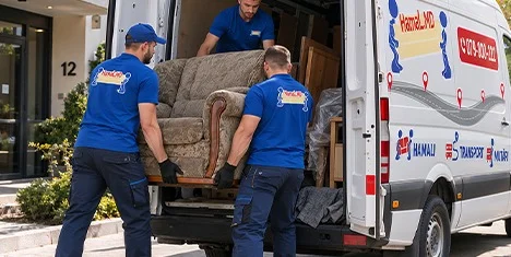 Doi hamali HamaL.MD încarcă o canapea veche în bus, lângă un bloc din Chișinău