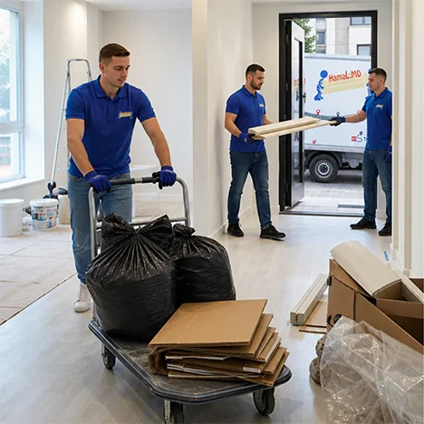 Hamali cară afară resturi de construcție folosind un cărucior de transport