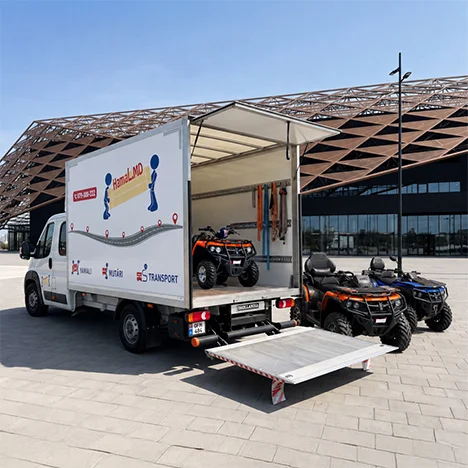 Trei ATV-uri sunt încărcate pe rampă într-un camion prelată